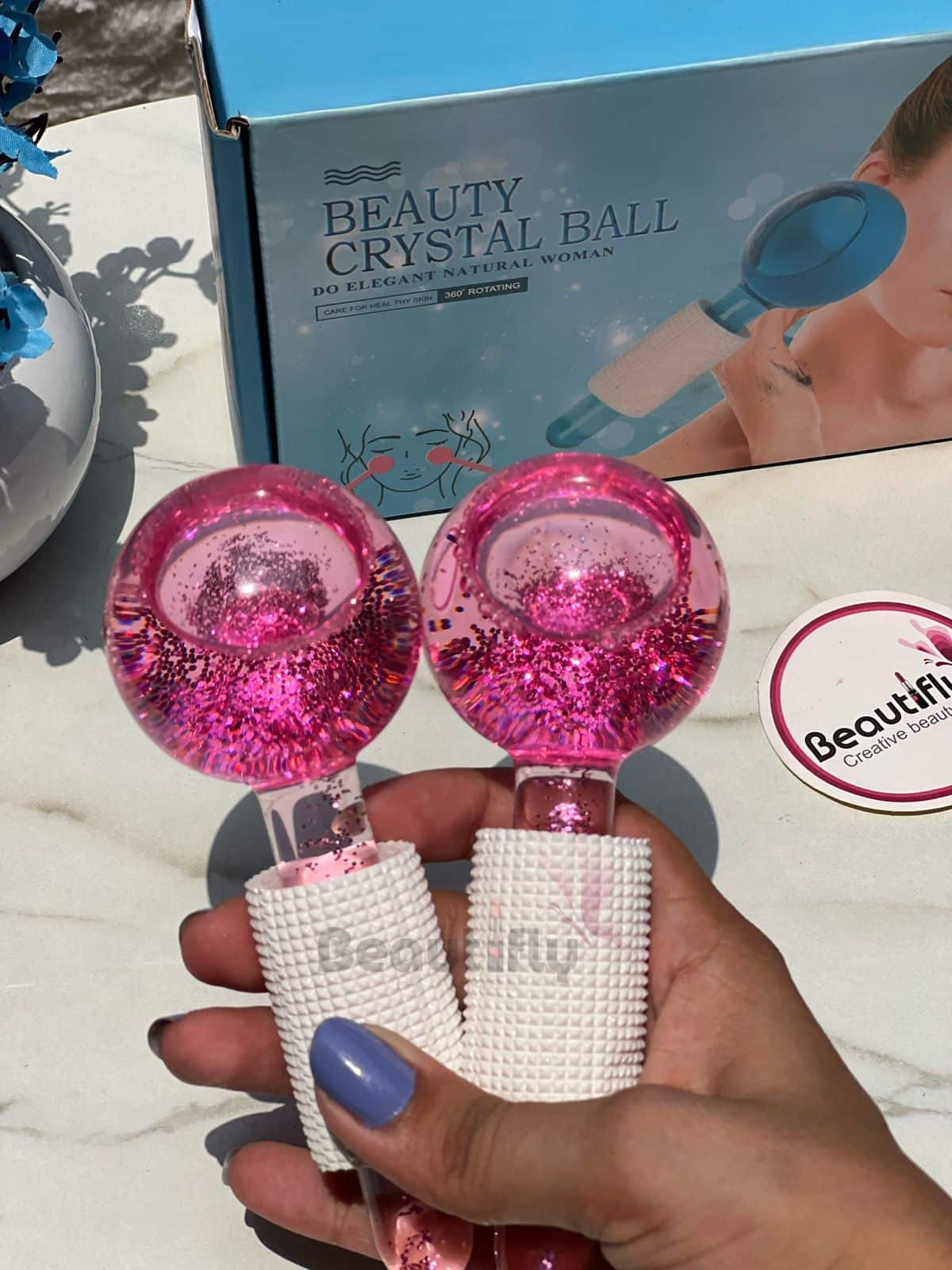 Pair of pink and blue crystal facial ice globes for cooling massage.