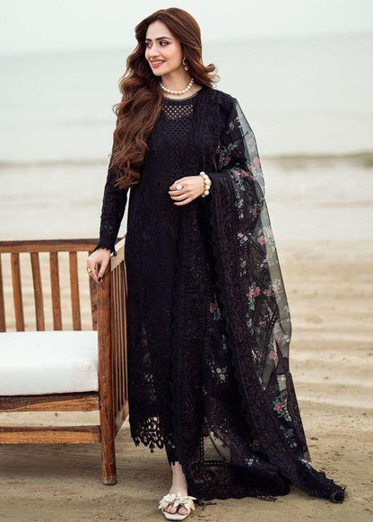 Model posing in a heavy black Chikankari embroidered suit with floral dupatta.