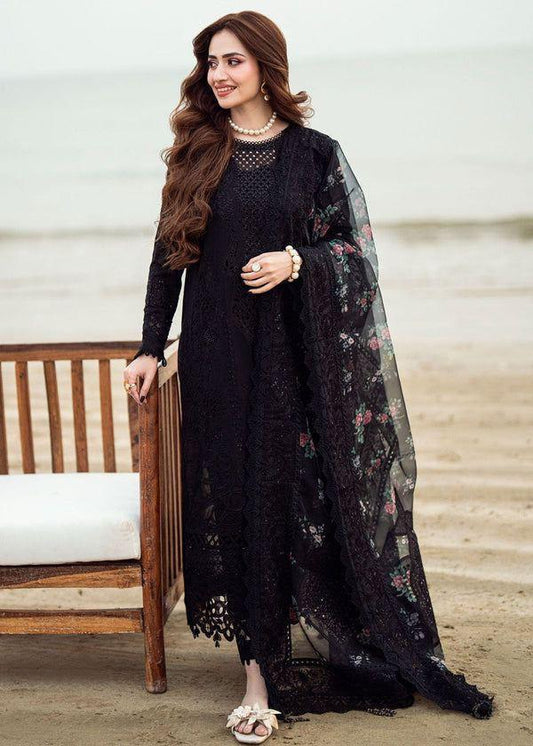 Model posing in a heavy black Chikankari embroidered suit with floral dupatta.