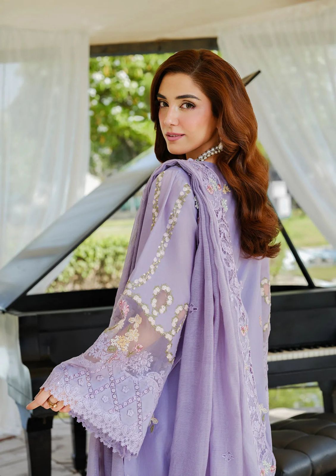 "Close-up of wide embroidered sleeves with delicate floral motifs and lace borders on a lavender dress."