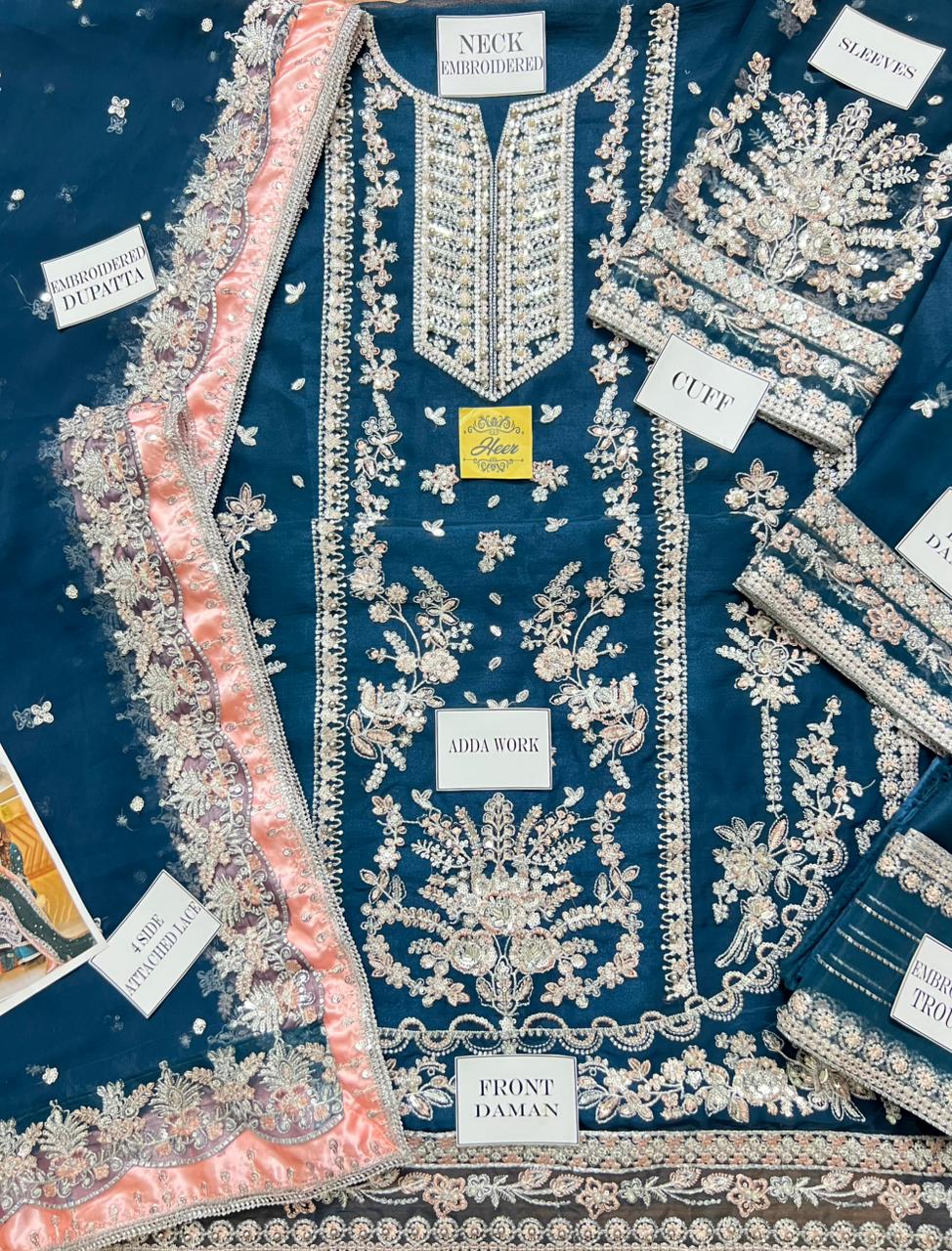 Close-up of intricate gold tilla work on a deep teal velvet festive dress.