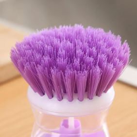 Hand-pressing-button-on-automatic-liquid-refill-kitchen-scrubber