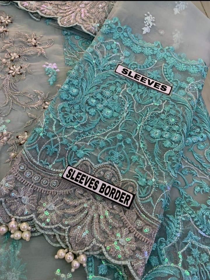 Detailed view of pearl-embellished sleeves on a designer grey organza wedding outfit.