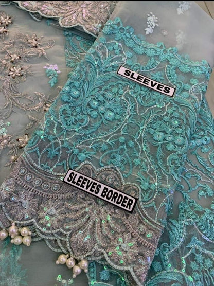 Detailed view of pearl-embellished sleeves on a designer grey organza wedding outfit.