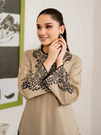 Close-up of a women's beige kurti with black floral embroidery on the neck and sleeves.